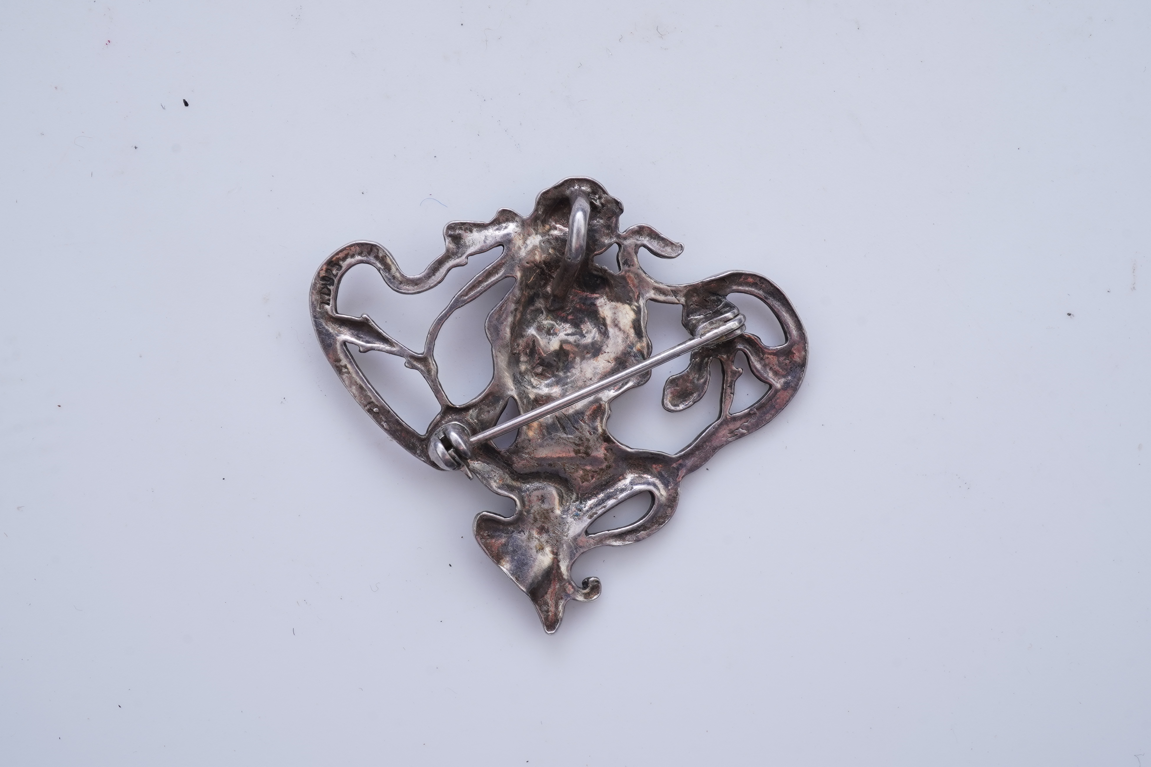 A collection of three silver chains and an Art Nouveau brooch, early 20th century